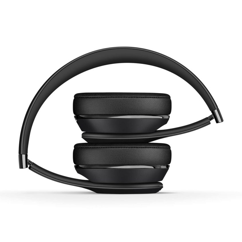 A pair of black over-ear headphones folded compactly with the ear cups pressed together and the headband curved around them, shown against a white background.