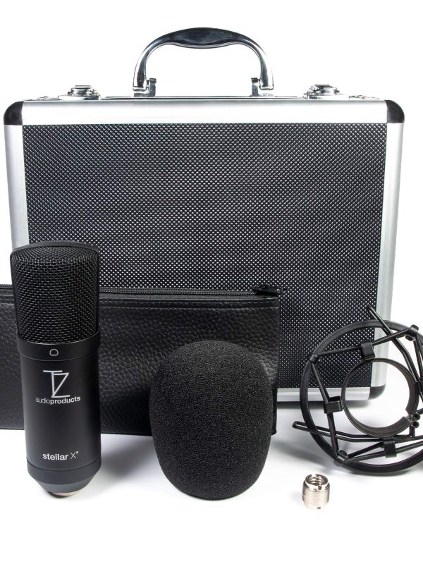 A black condenser microphone with a foam windscreen, shock mount, carrying case, zippered pouch, and a small metal adapter, all arranged in front of a silver and black hard case with a handle.