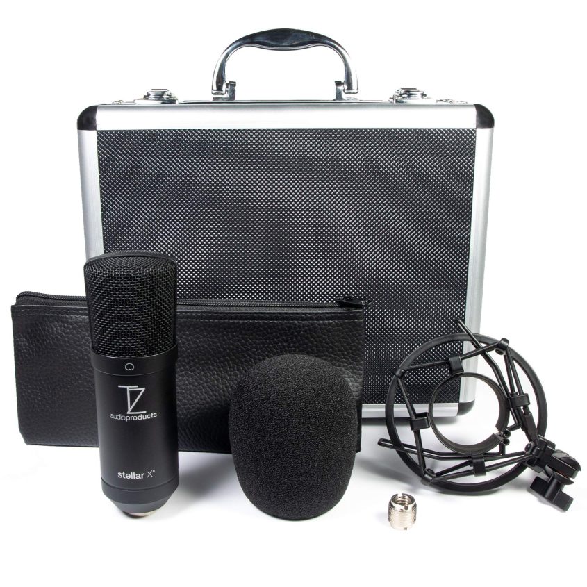 A black condenser microphone with a foam windscreen, shock mount, carrying case, zippered pouch, and a small metal adapter, all arranged in front of a silver and black hard case with a handle.