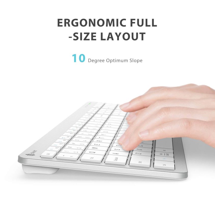 A hand typing on a white, slim, full-size keyboard with an ergonomic 10-degree slope. Text above highlights the Ergonomic Full-Size Layout and 10 Degree Optimum Slope.