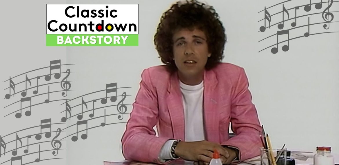 A man with curly hair in a pink blazer sits at a desk with papers and a glue bottle, channeling Prince vibes, with musical notes and the Classic Countdown Backstory logo in the background.