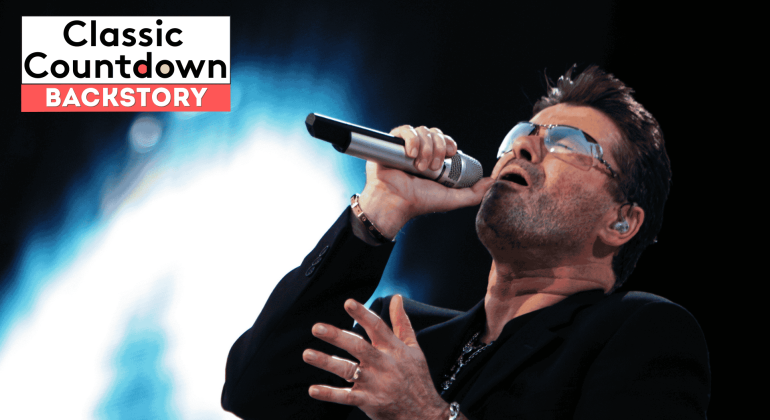 A man wearing sunglasses and a black jacket passionately sings "Last Christmas" into a microphone on stage. The text Classic Countdown BACKSTORY appears in a box in the top left corner. The brightly lit background adds to the festive atmosphere.