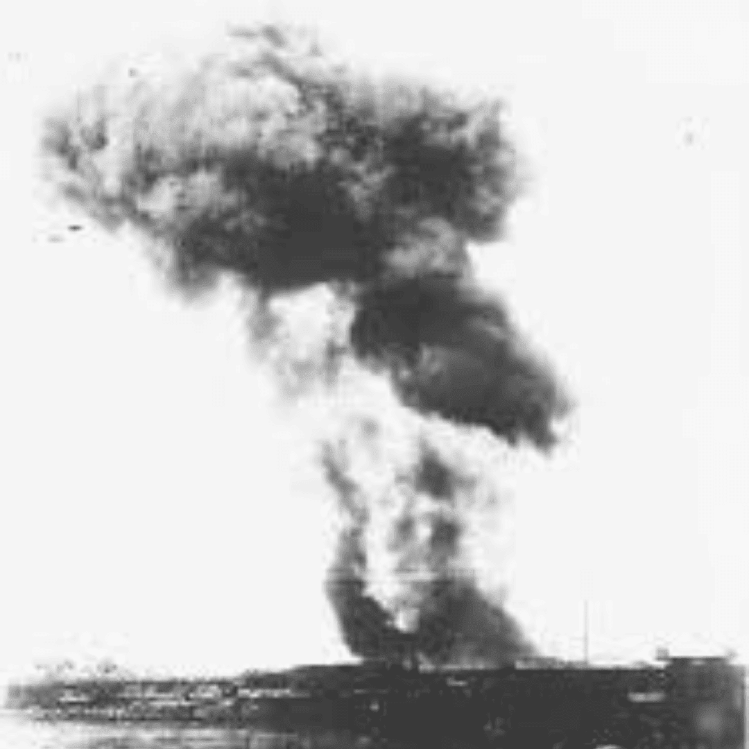 A large, dark cloud of smoke rises high into the sky from a structure on the ground, resembling images from Miriam Makeba’s era; the monochrome scene suggests a significant explosion or fire in a historical context.